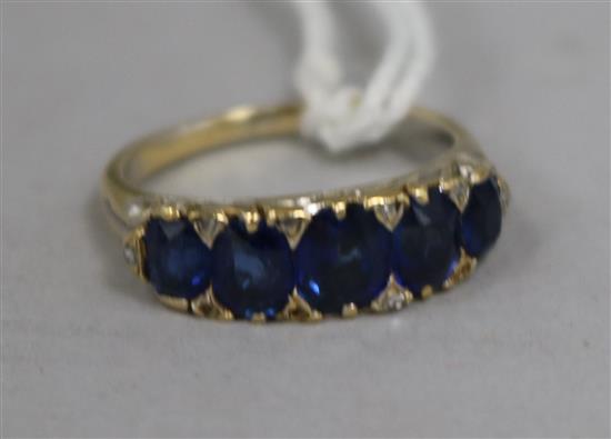 A gold, five stone graduated sapphire and diamond chip set half hoop ring, size M.